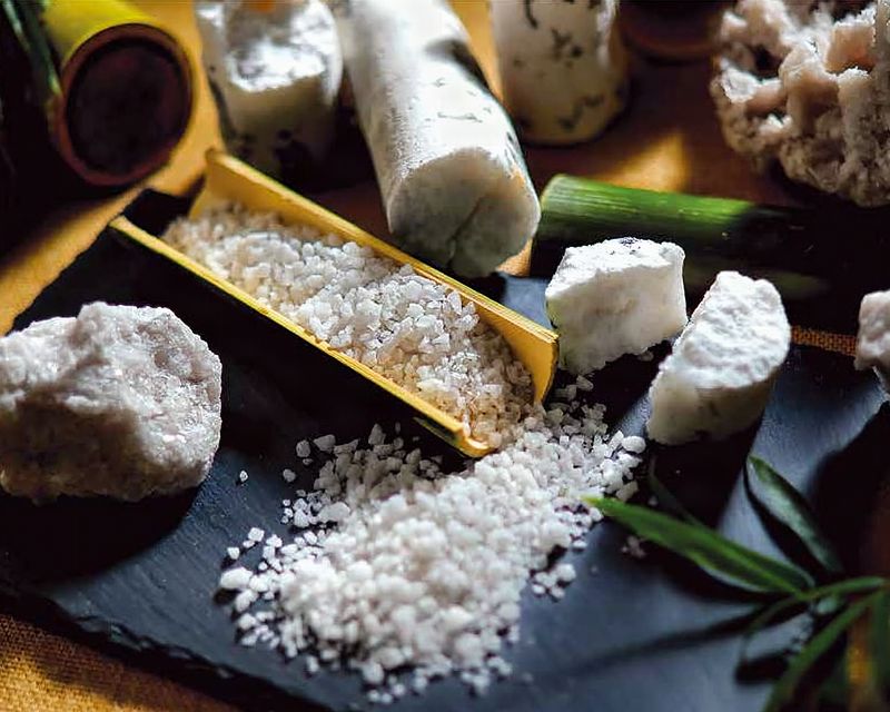 Bamboo salt crystals and powder on slate with bamboo